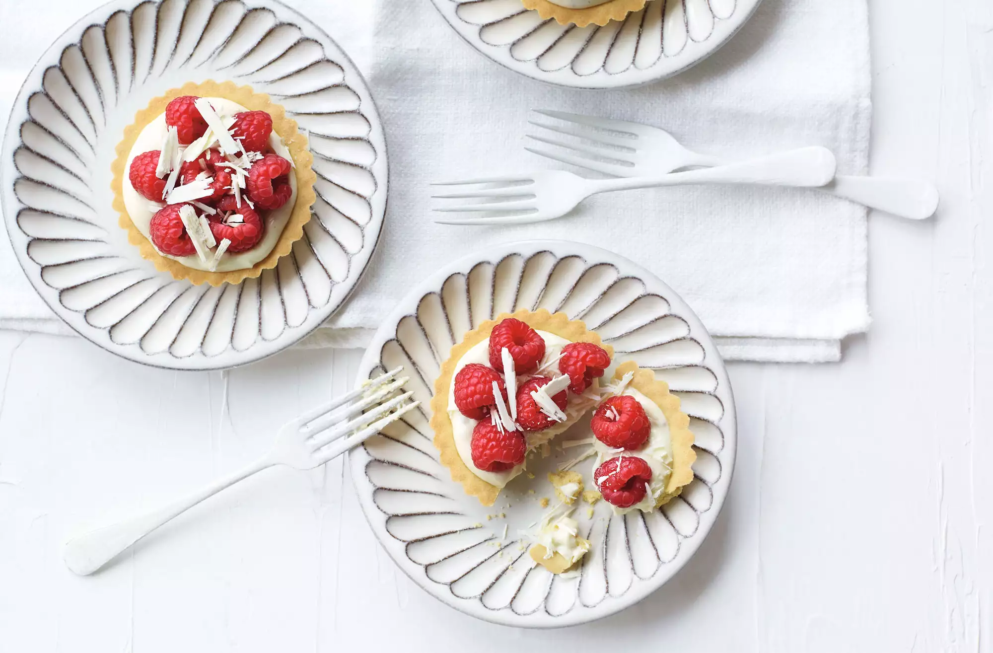 Raspberry, white chocolate & cardamom tarts