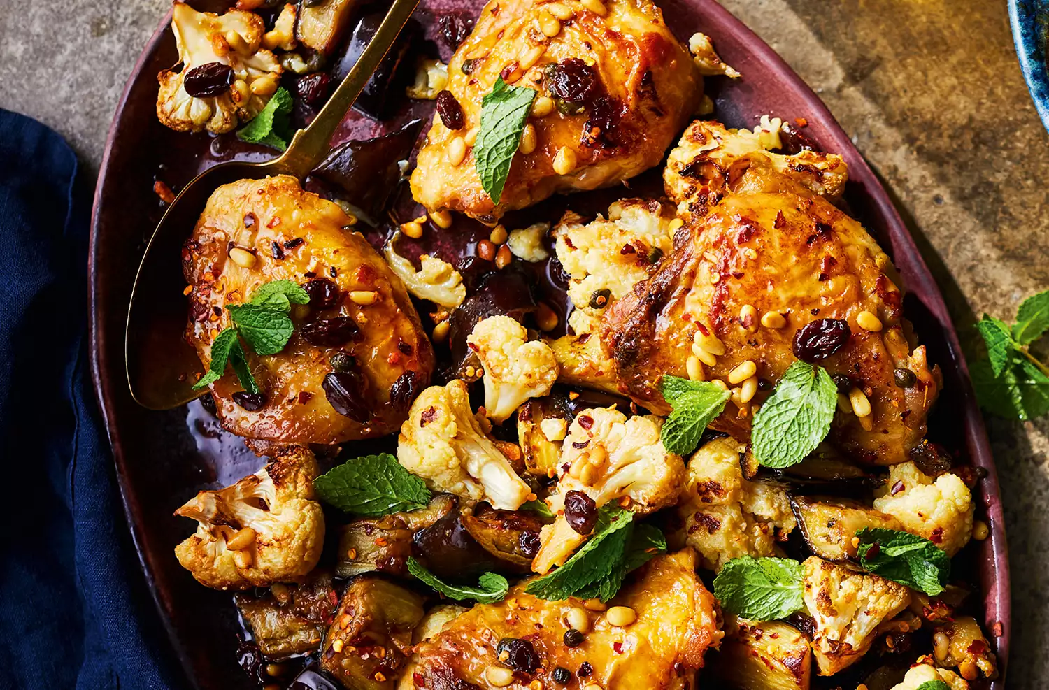 Chicken roasted with cauliflower, aubergines, raisins, pine nuts & capers